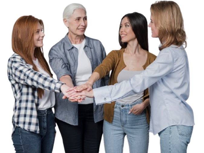 Four women standing in a circle, placing their hands together in the center, symbolizing unity and support in relationships.